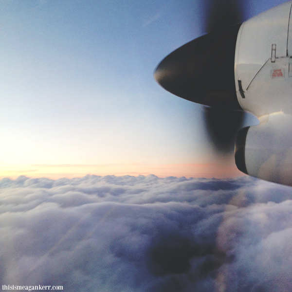 Sunset over clouds from inside plane