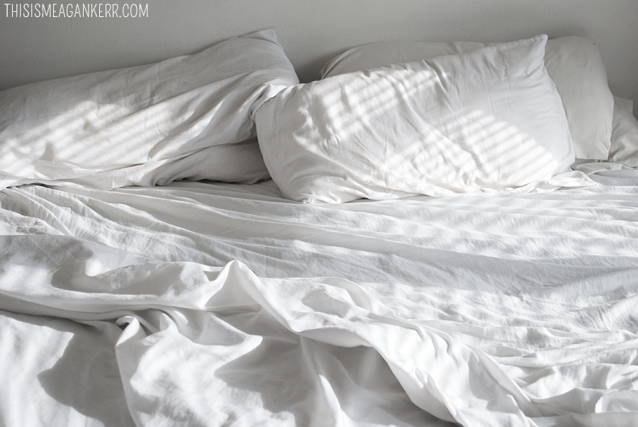unmade bed rumpled white sheets