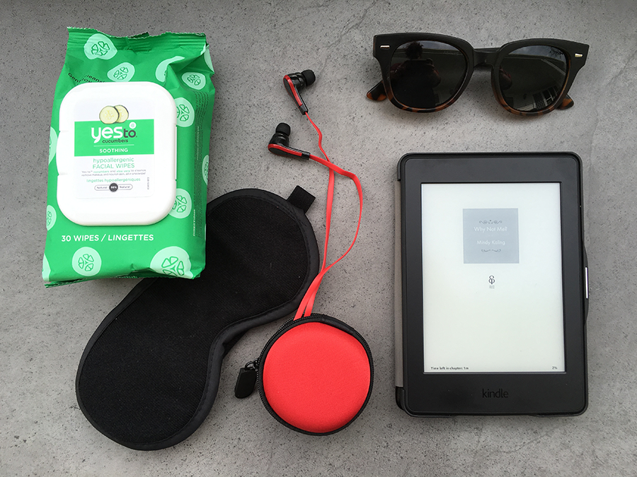 What I'm taking in my carry on luggage: face wipes, eye mask, ear bud headphones, sunglasses and Kindle