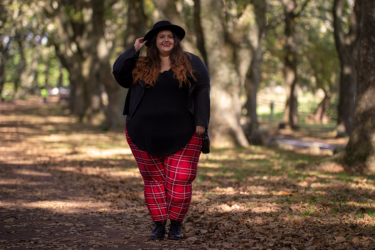 New Zealand plus size fashion blogger Meagan Kerr wears V-Neck Tunic Tee from Torrid, boohoo Plus Tartan Leggings, Snap Short Jacket from Taking Shape, Limited Edition Lecester Boots from Number One Shoes, ASOS DESIGN Wide Brim Pork Pie Hat from ASOS and Winona Crossbody Bag from Velvet Heartbeat