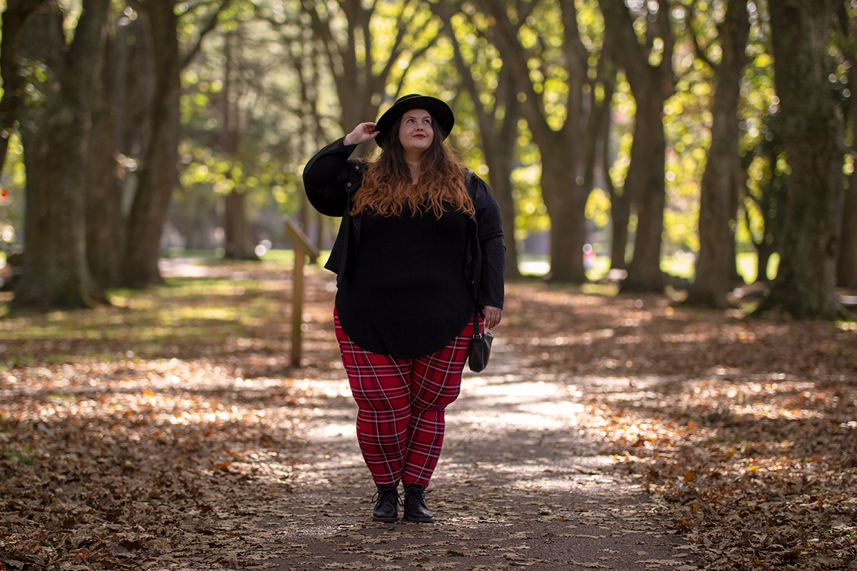 New Zealand plus size fashion blogger Meagan Kerr wears V-Neck Tunic Tee from Torrid, boohoo Plus Tartan Leggings, Snap Short Jacket from Taking Shape, Limited Edition Lecester Boots from Number One Shoes, ASOS DESIGN Wide Brim Pork Pie Hat from ASOS and Winona Crossbody Bag from Velvet Heartbeat