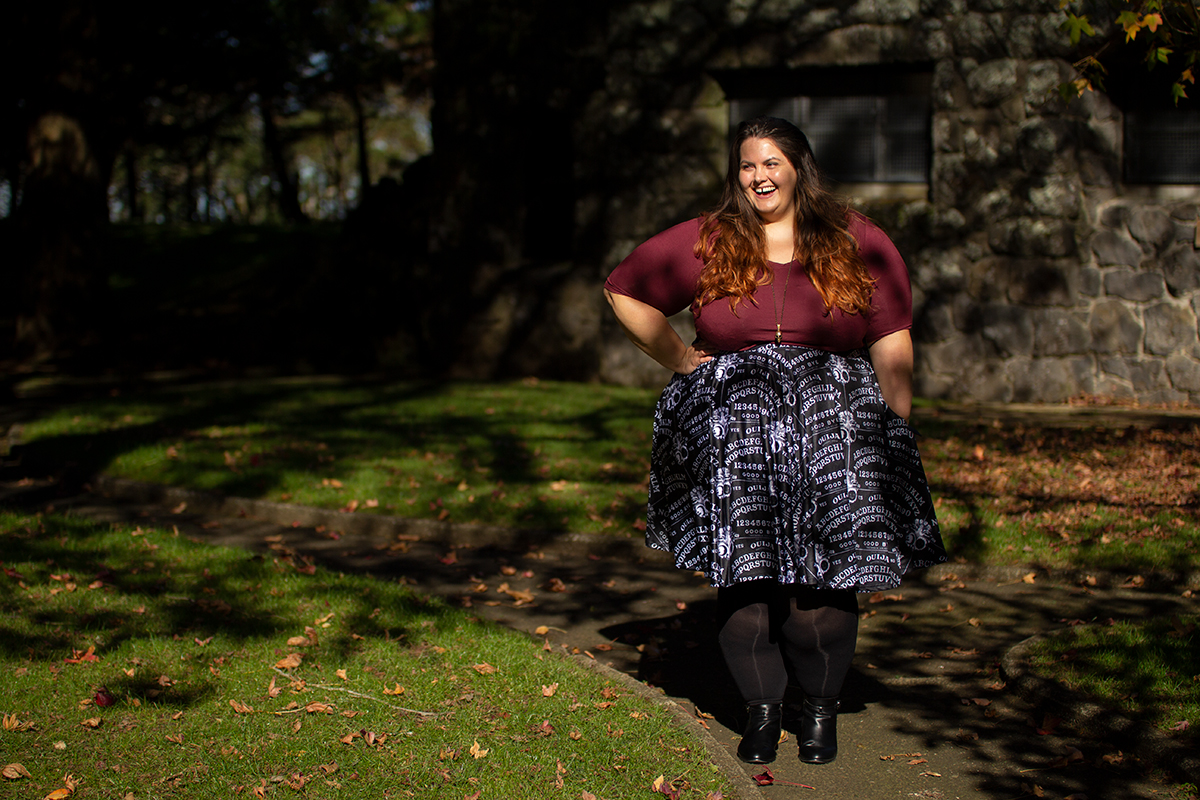 New Zealand plus size blogger Meagan Kerr wears v-neck tunic from Torrid, ouija print skirt from Joolz Fashion, stockings from Snag Tights, boots from Autograph Fashion and skull necklace from Luke Adore Jewellery