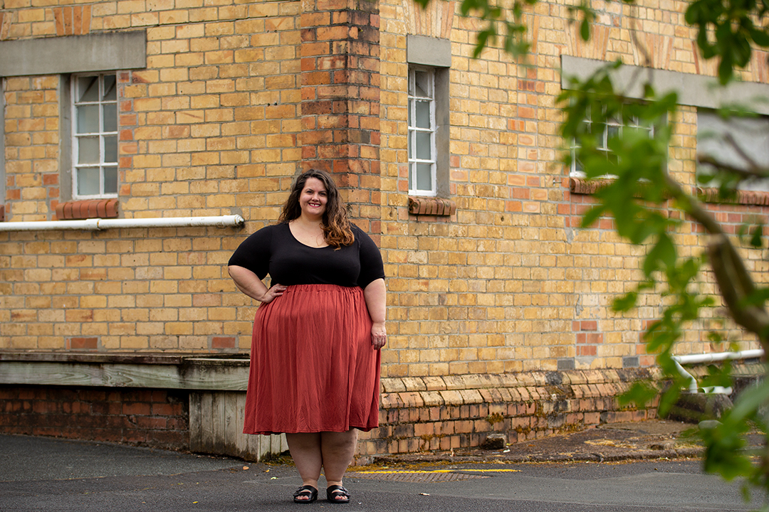 New Zealand plus size fashion blogger Meagan Kerr wears black Torrid tee and terracotta boohoo Plus Jersey Pleated Midi Skirt with Ziera Mason Sandals 