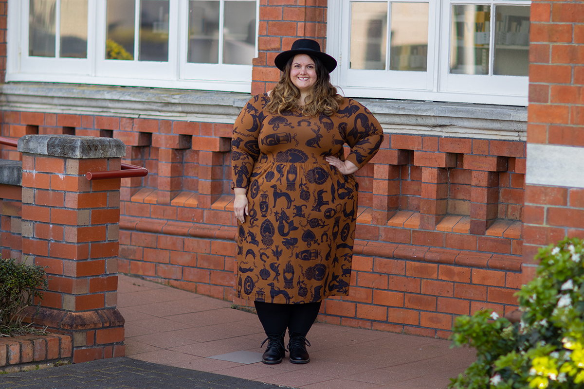 New Zealand plus size fashion blogger Meagan Kerr wears Made590 Sweeney Dress in Charmed, Snag Tights in black, ASOS DESIGN Pork Pie Hat from ASOS and Limited Edition Lecester Boots from Number One Shoes