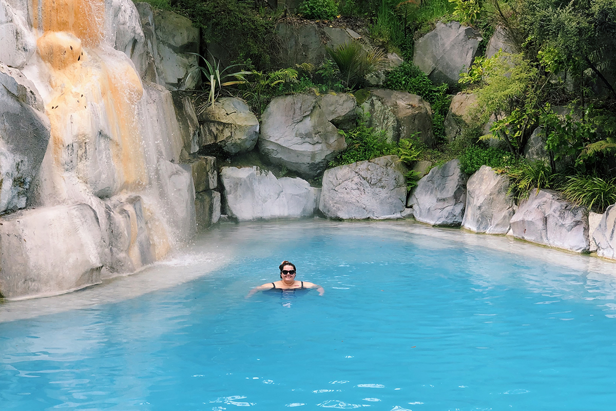 New Zealand plus size blogger Meagan Kerr swimming in front of the waterfall at Wairakei Terraces Thermal Pool