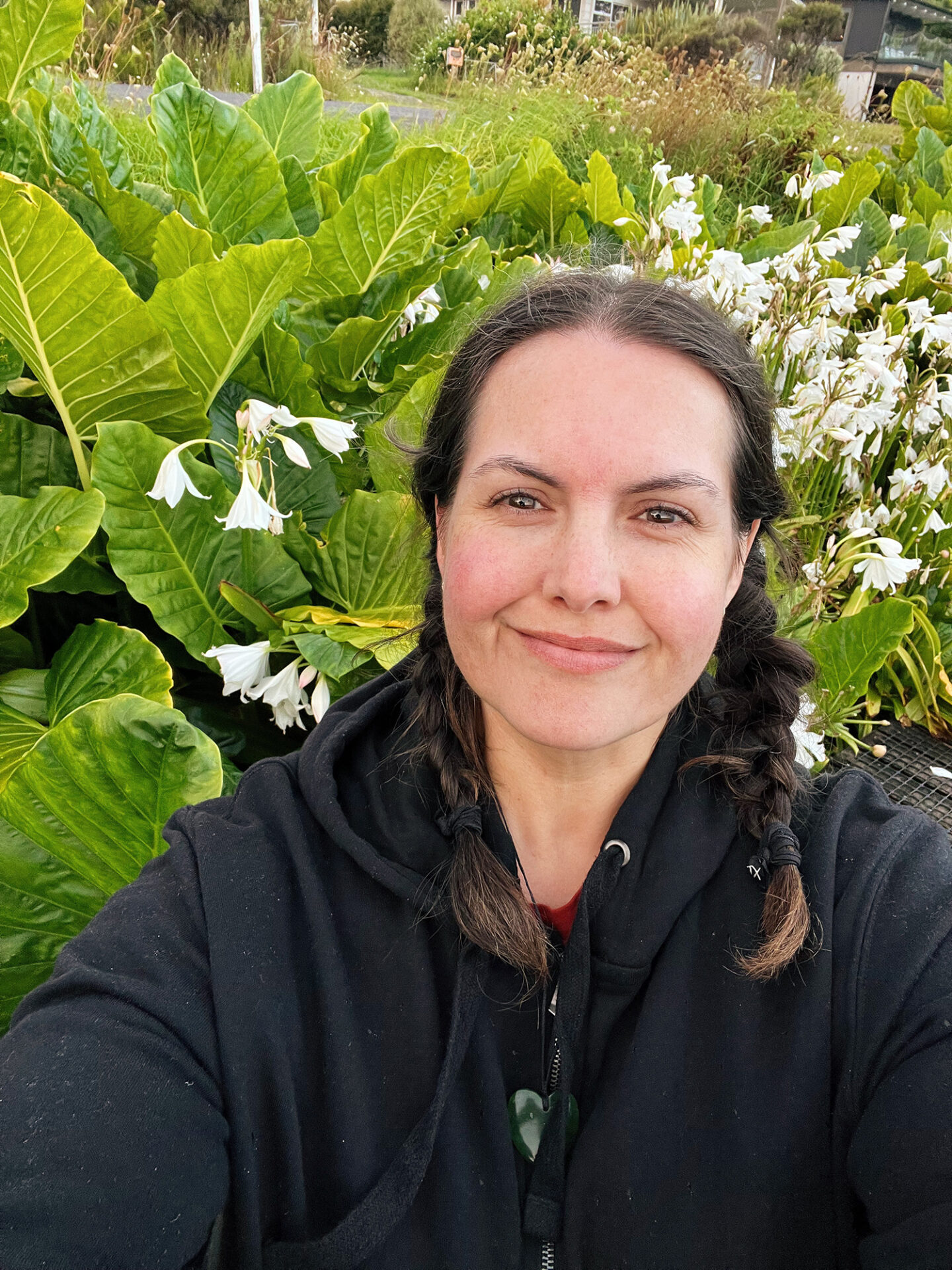 A selfie of Meagan with some big lush leaves.