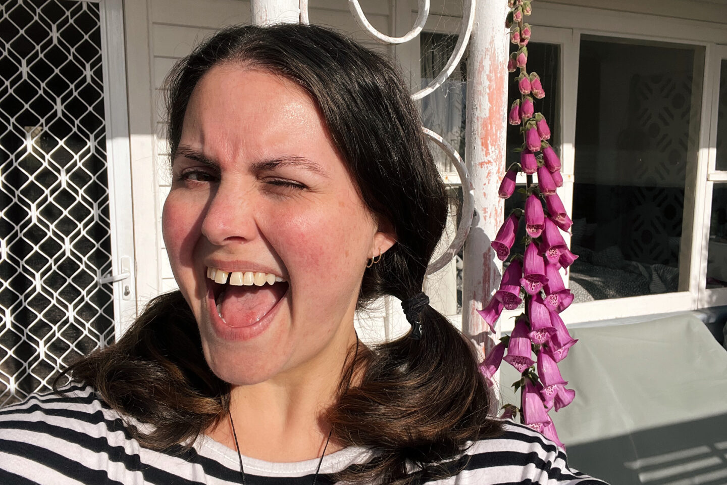 A selfie of Meagan with a foxglove flower she grew.