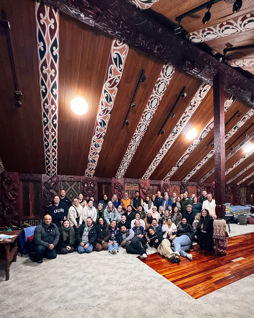 A group of people inside a wharenui.